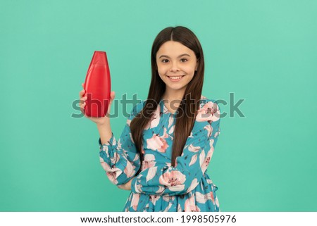 smiling kid with long hair hold shampoo bottle, hairdresser