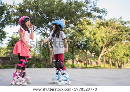 smiling 5 year old asian girl going on her in-line skates