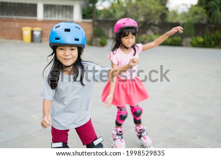 two asian girl going on her in-line skates in the park