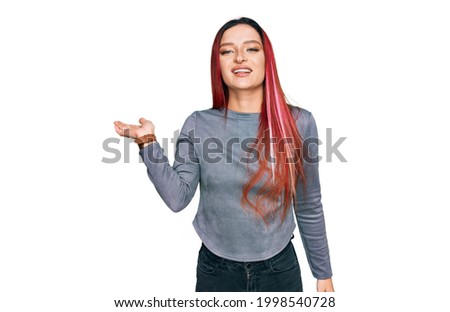 Young caucasian woman wearing casual clothes smiling cheerful presenting and pointing with palm of hand looking at the camera. 
