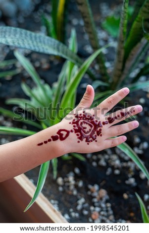 Henna ornaments on little girl's hand closeup.