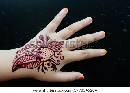 Henna ornaments on girl's hand closeup.