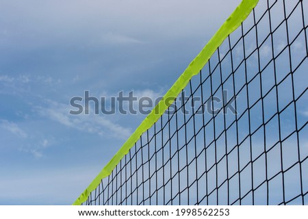 Beach volleyball and beach tennis net on the background of blue sky with clouds. Summer sport concept.