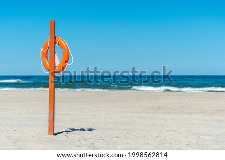Life buoy preserver on sandy beach somewhere
