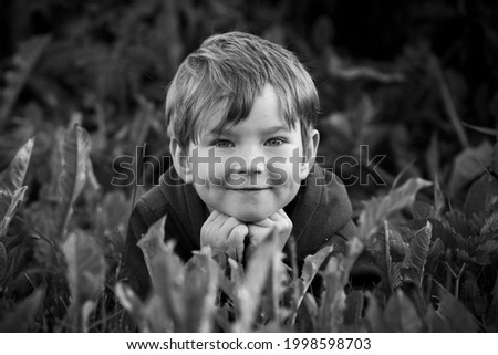 Portrait of a little boy outside the city, close-up. Black and white photo.
