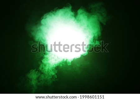 Smoke in green light on black background