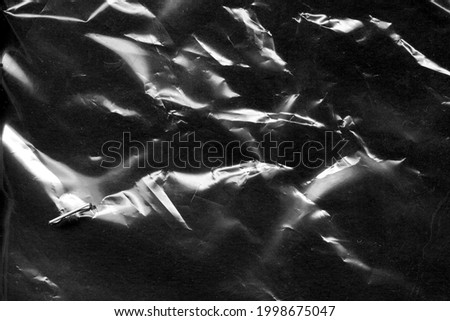 Beautiful darkness plastic abstract background. No plastic bag concept, save world, protect earth. Freeze motion of dark powder exploding. Glossy polyethylene. plastic transparent. Space for text.  Royalty-Free Stock Photo #1998675047