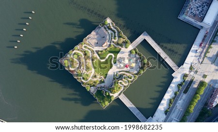 An aerial view over Manhattan's new Little Island. A green space that looks like it's floating on the water of the Hudson River. Taken at sunrise with a drone while the river was calm. Royalty-Free Stock Photo #1998682235