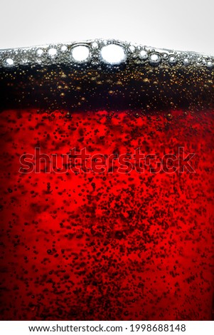 Glass of red beer with foam and a lot of bubbles, on a white background. Close-up macro photography. Royalty-Free Stock Photo #1998688148