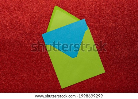 Envelope with blank space for text or greeting on red background, as symbol of getting mail, advertisement element. 