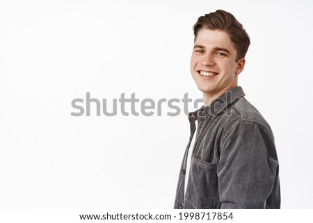 Close up of handsome happy candid boy, young man turn face at camera with white smile, positive cheerful face, looking at camera, white background Royalty-Free Stock Photo #1998717854
