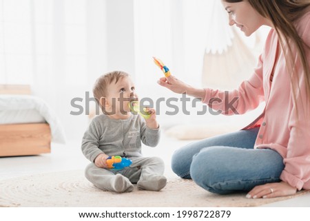 Happy mother nanny babysitter playing games with little small kid child toddler newborn baby infant, developing skills and imagination, learning educating son daughter before kindergarten. Motherhood Royalty-Free Stock Photo #1998722879
