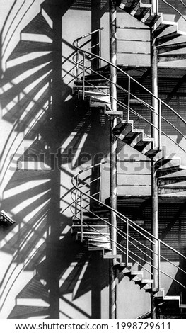 A black and white photograph of a winding staircase