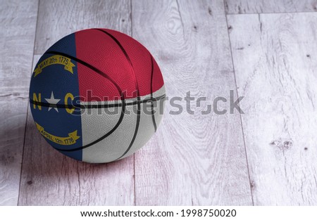 North Carolina flag is featured on a basketball. Basketball championship concept.