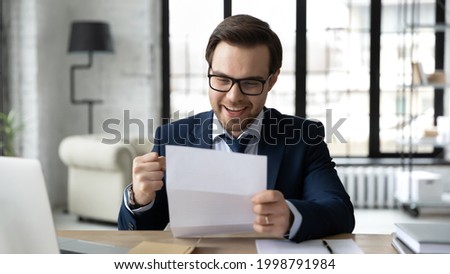 Happy businessman learning good news, reading letter, getting document from bank with approval loan or mortgage, receiving insurance notice, professional certificate. Paperwork, correspondence concept Royalty-Free Stock Photo #1998791984