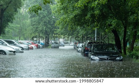 Flooded cars on the street of the city. Street after heavy rain. Water could enter the engine, transmission parts or other places. Disaster Motor Vehicle Insurance Claim Themed. Severe weather concept Royalty-Free Stock Photo #1998805847