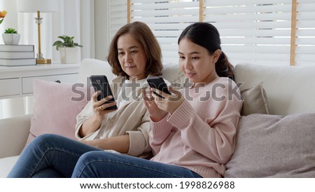 Attractive beautiful asian family sit sofa couch living room enjoy urban life joyful promotion discount shop buy health care insurance online quarantine activity isolate omnichannel experience at home Royalty-Free Stock Photo #1998826988