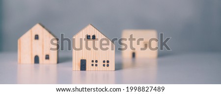 Mini wooden home model concept, investment of real estate and asset, tax of property and rental for finance, no people, small house and inspiration, mortgage and loan for residence, business concept.