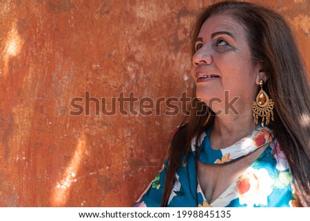 Portrait of an elderly woman with long hair in the street