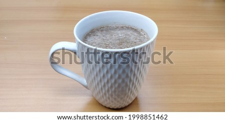 Hot Drink of Chocolate Cereal in White Mug on Wooden Table