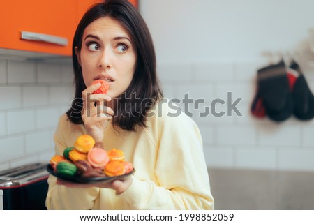 Woman Eating Macarons Feeling Guilty and Hiding. Adult person with sugar addiction hiding her alimentary habits over indulging because of stress
 Royalty-Free Stock Photo #1998852059