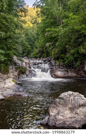 A popular swimming hole, Bust Your Butt Falls is a small waterfall on the Cullasaja River in Nantahala National Forest near the town of Highlands in the beautiful mountains of western North Carolina. Royalty-Free Stock Photo #1998863279