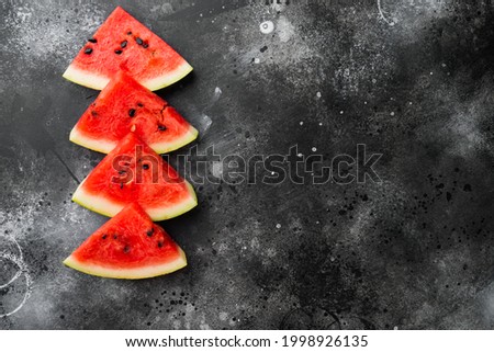 Fresh cut watermelon set, on black dark stone table background, top view flat lay, with copy space for text