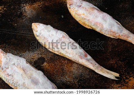 Frozen surmullet  fish set, on old dark rustic table background