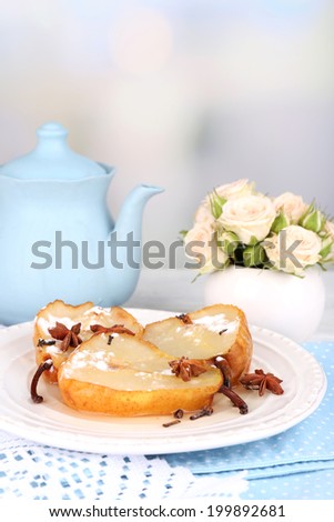 Baked pears with syrup on plate, on bright background