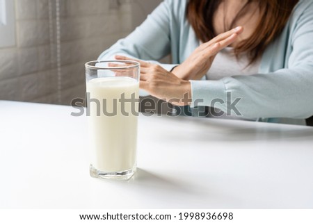 Female making X sign with crossed hands, gesturing stop or say no to drink milk. Lactose intolerance, food allergy concept. 