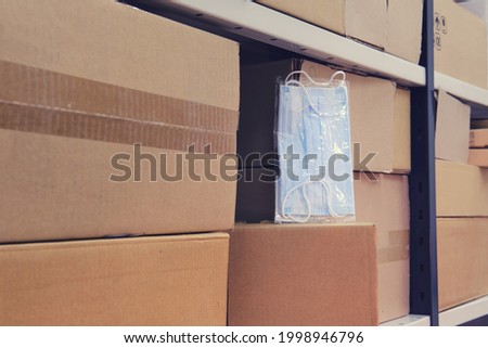 Packaging of protective medical masks in the warehouse among cardboard boxes