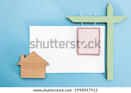 The concept of mortgage, sale and rental of housing and real estate. A sign about the sale or lease of a house against against the background of a business card with a house. Copy space. Mock-up