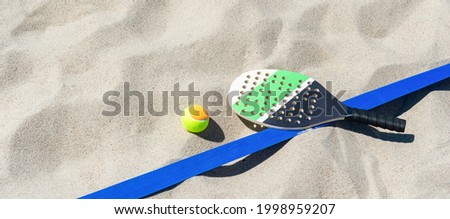 Racket and ball on the sandy beach. Summer sport concept