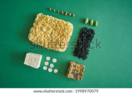 Flat lay Concept ramen soup ingredients noodle, egg, wakame algae, lime, tofu, soy meat on green background. High quality photo
