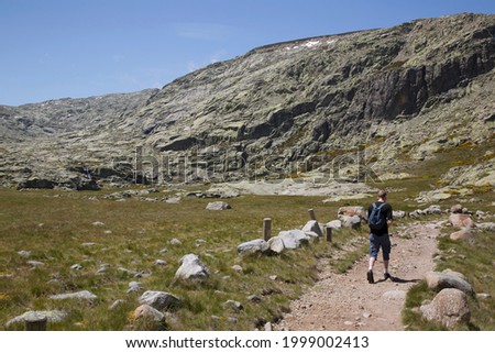 wide mountain landscape with hiking trail and mountain hiker with backpack in the great outdoors of Sierra de Gredos