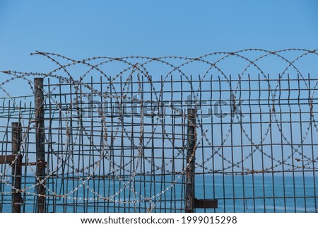 razor wires, rusty and old lattice fence