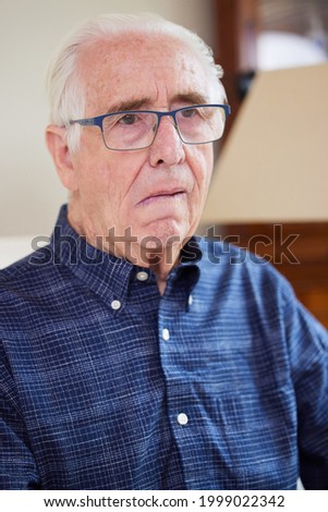 Portrait Of Senior Man At Home Suffering From Stroke Showing Dropped Side Of Face Royalty-Free Stock Photo #1999022342