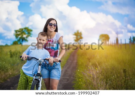family. mother and son riding  in the park
