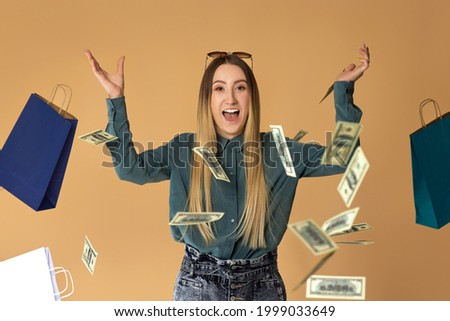 woman holds cash money under dollar's rain.
