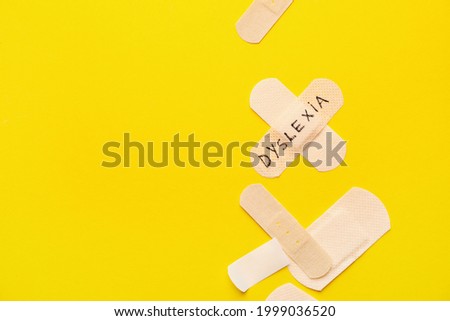 Medical patches with word DYSLEXIA on color background