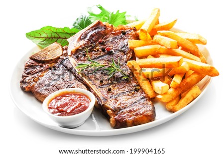 Tender grilled porterhouse or t-bone steak served with crisp golden French fries and fresh green herb salad accompanied by a BBQ or tomato ketchup sauce Royalty-Free Stock Photo #199904165