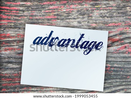 Advantage word on page and paper dollar signs around on wooden table. business concept