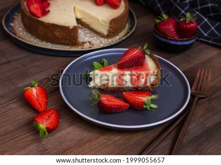 cream cheesecake with strawberries, mint and chocolate. portions of dessert on a dark wooden background 