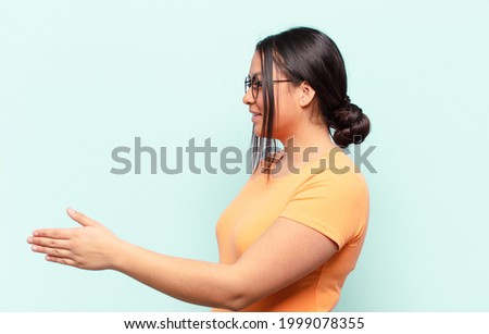 latin woman smiling, greeting you and offering a hand shake to close a successful deal, cooperation concept