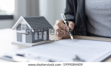 Selling a house with insurance, Sales managers or dealers have signed approval to open a housing project with a model house, Home-Real Estate and Insurance concept.