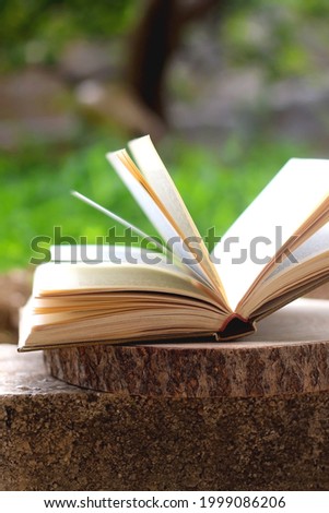 Open book in a garden. Selective focus.