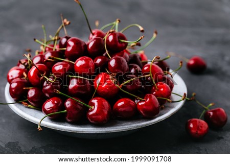 Cherry. Sweet Cherries in bowl on dark stone concrete background. Ripe Sweet Red Cherries.