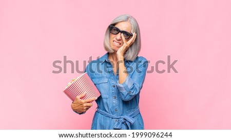middle age woman feeling bored, frustrated and sleepy after a tiresome, dull and tedious task, holding face with hand movie concept