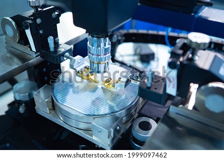 Chip testing equipment. Manufacturing of microchips. A close-up study of a test sample of a transistor chip under a microscope in the laboratory. Automation of production. Royalty-Free Stock Photo #1999097462