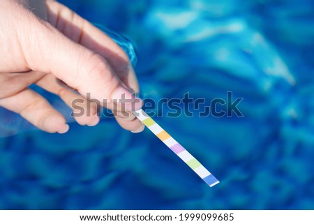 Testing the water quality in the pool with test strips  Royalty-Free Stock Photo #1999099685